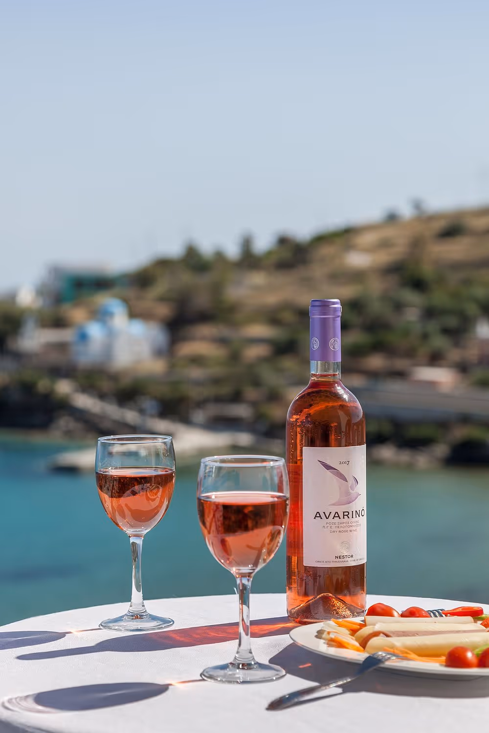 Rose wine glasses overlooking the Aegean sea from our Syros Hotel